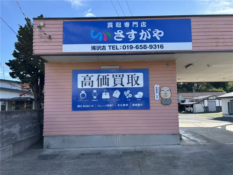 さすがや滝沢店の外観。青い「買取専門店 さすがや」の看板が掲げられたピンク色の建物